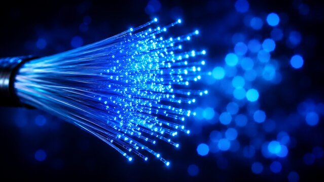 Bright blue light illuminates the ends of optical fibers representing high speed internet and global telecommunications connectivity.