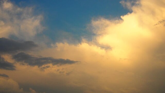 A stunning display unfolds as dusk approaches, painting the sky with hues of gold and orange. Wispy clouds dance gracefully, creating a mesmerizing tableau above