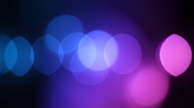 Vibrant Bokeh Lights with blue and purple glowing circles on black background, ideal for cinematic overlays.