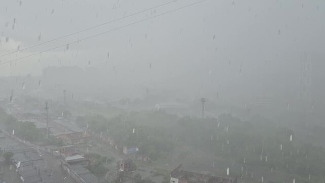 A torrential downpour accompanied by hail is raging over the city.
