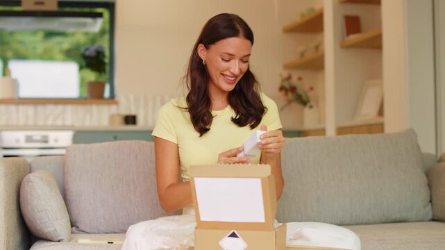 Cheerful woman unboxing delivery parcel with new skincare cosmetics at home, 4K