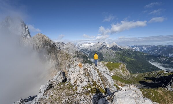 Hikers at the summit of the Westliche T&ouml;rlspitze, in the background cloudy feslige summit of the Partenkirchner Dreitorspitze, view of Reintal and Zugspitze with Zugspitzplatt, Wetterstein range, Garmisch Partenkirchen, Bavaria, Germany