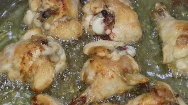 Close-up of chicken drumettes deep frying in hot oil