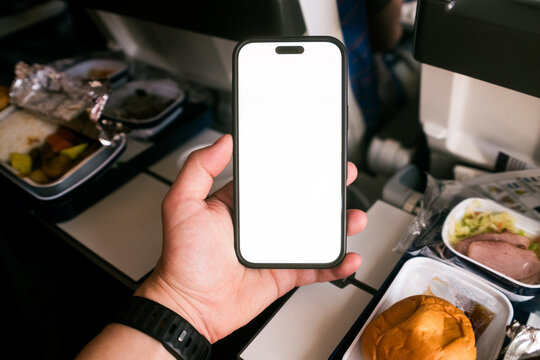 A man uses a mobile phone with white screen on an airplane