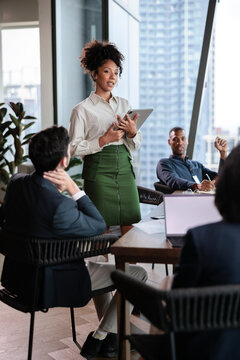 Businesswoman leading team meting with digital tablet in office