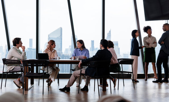 Diverse team meeting in modern office with city view.