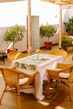 Table set with elegant tablecloth and decorated with a yellow flower