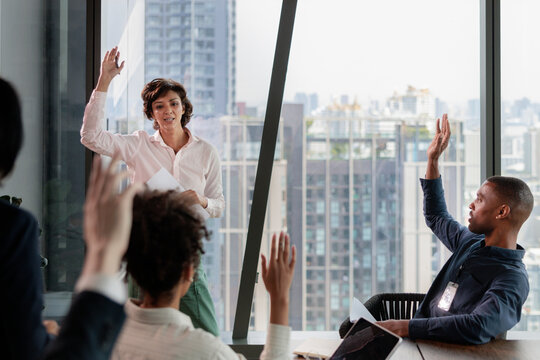 Business meeting with hands raised in front of city view.