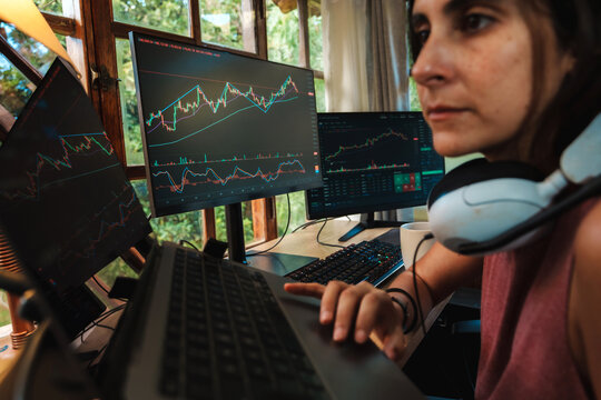 woman Trading Stock on Multiple Screens at Home office setup