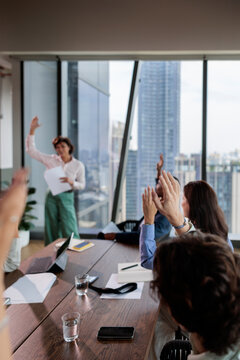 Business meeting with presenter and raised hands.