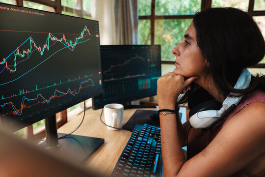 woman Trading Stock on Multiple Screens at Home office setup