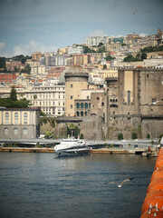 Fototapeta premium White motor yacht docked near a Naples city harbor