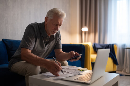 Senior man calculating taxes at home