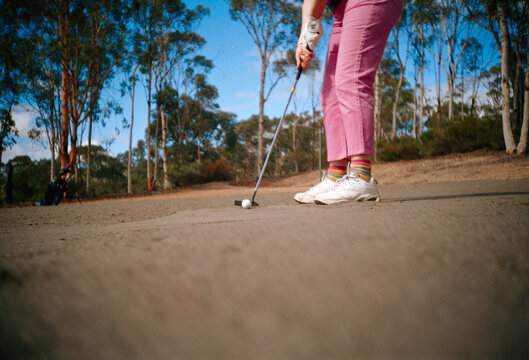 Golfer Prepares to Putt on a Sunny Day at Country Golf Course