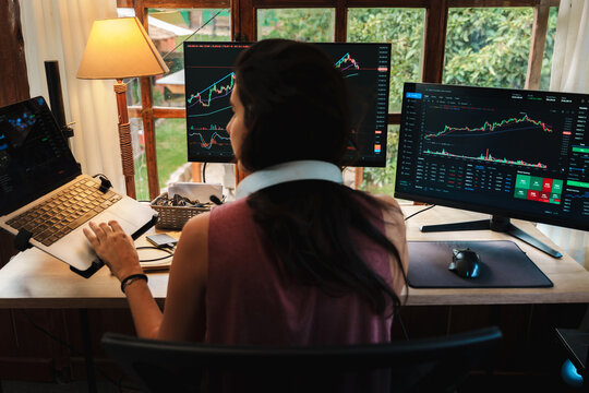 woman Trading Stock on Multiple Screens at Home office setup