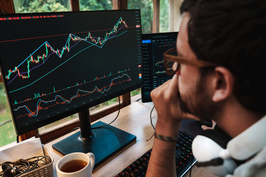 man Trading Stock on Multiple Screens at Home office setup
