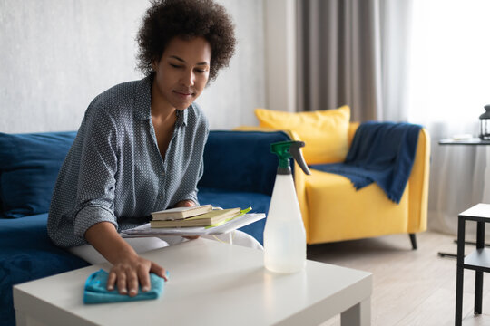 Black woman wiping table at home