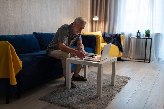 Senior man checking bills at home