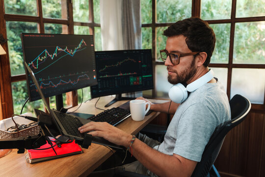 man Trading Stock on Multiple Screens at Home office setup