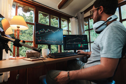 man Trading Stock on Multiple Screens at Home office setup