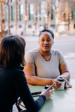 Two women talking sitting on the cafe terrace
