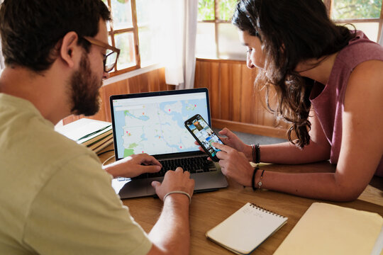 Couple Planning a Trip Together with Laptop and Phone