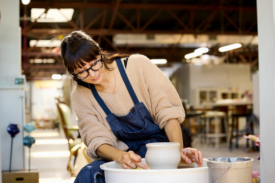 Potter Crafts Clay Bowl in Studio