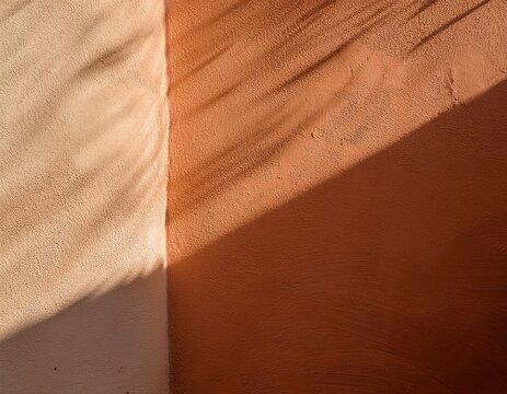 abstract terracotta and cream plaster wall with sunlight shadows