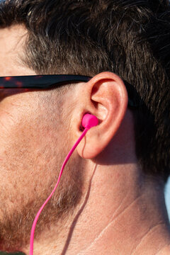 Man Listens to Music With  Earbuds