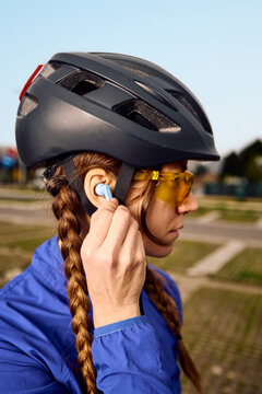Cyclist Prepares for Ride While Adjusting Earbud