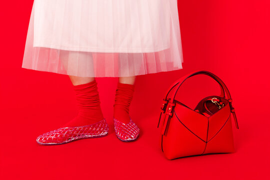 Person standing with red socks and red bag