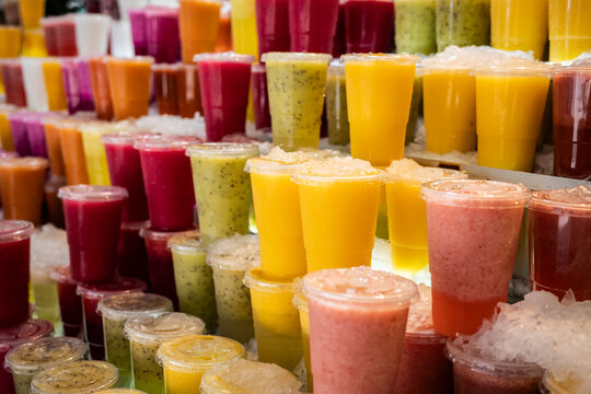 Colorful Drinks in Clear Cups Displayed in a Market Setting