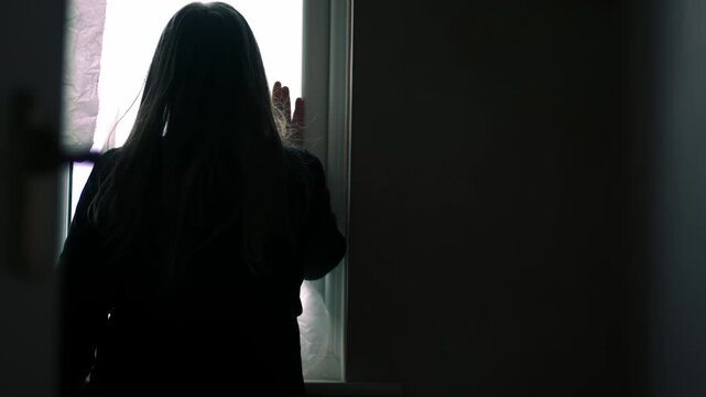 Silhouette of Woman looking through window through view of door
