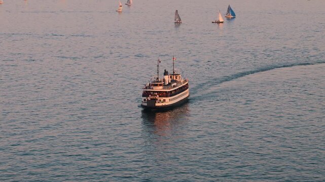 Scenic high angle view of two traditional passenger ferries sailing across the blue water of Toronto Harbour toward Toronto Island