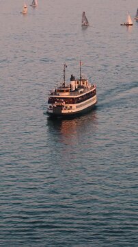 Scenic high angle view of two traditional passenger ferries sailing across the blue water of Toronto Harbour toward Toronto Island