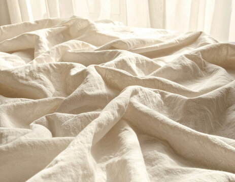 Cozy bed set by the window with natural linen pillows and crumpled white sheets in morning light