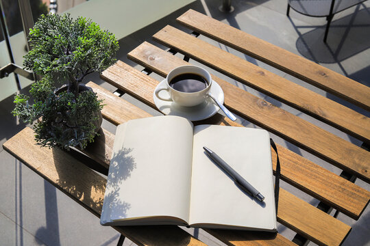 Notebook with pen and coffee on the table