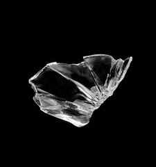 Fototapeta premium Jagged Shattered Glass Fragment Close-Up Isolated on Black Background