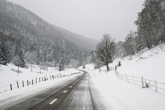 Mountain road and farmhouse at Orvin in winter, Bern canton, Switzerland