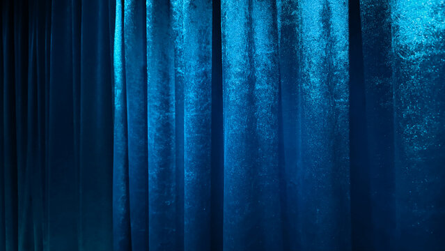 Luxury Blue Velvet Curtain Background with Dramatic Light and Shadow Texture Vertical Folds of Royal Indigo Satin Fabric Backdrop for Theater Stage Cinema Premiere and Elegant Event Decor.
