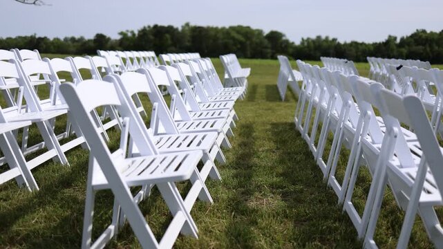 White chairs arranged for outdoor ceremony