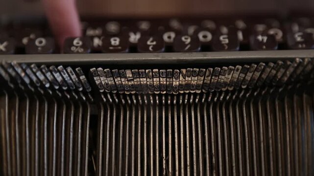 Typing on an old vintage typewriter. Typebar letter stamps close up. 