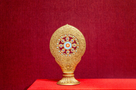Golden Buddhist ritual ornament on red background