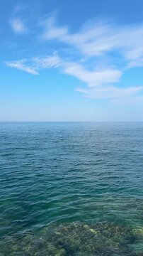 Open blue sea and sky clouds horizon, vertical video.