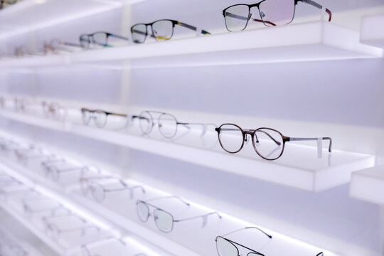 Eyeglasses are displayed on shelves in optical store