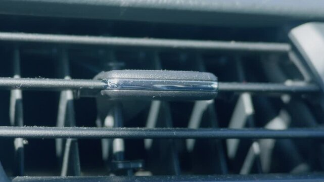 Macro view of dusty car dashboard air vent slatted grill