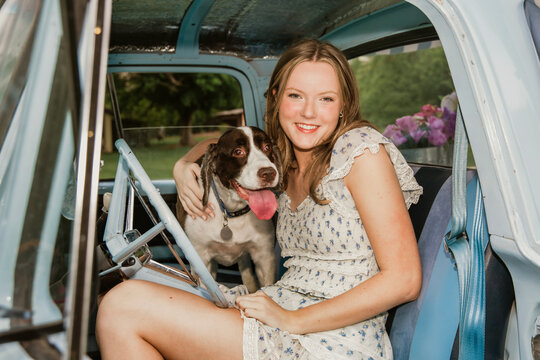 Young woman in truck with dog