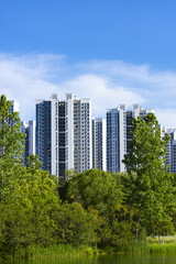 Fototapeta premium High Rise Apartment Buildings Above Green Park and Lake