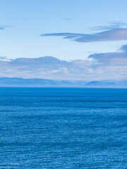 Obraz premium Calm Blue Ocean Horizon Over Sooke Coastline With Distant Islands and Cloudy Sky on Vancouver Island