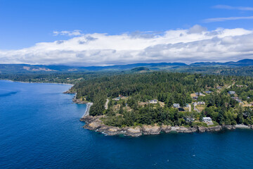 Obraz premium Aerial View Of Otter Point Coastline And Forested Seaside Homes On Vancouver Island, British Columbia